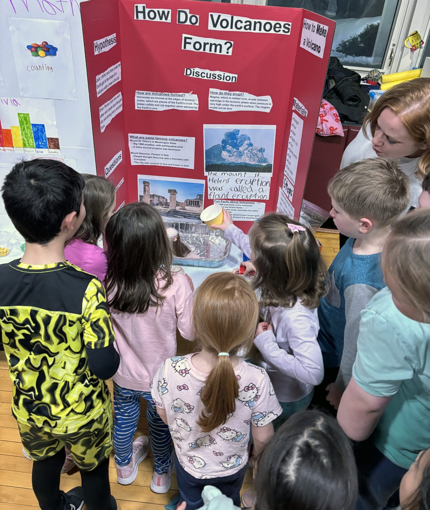 IMG_3166 A group of children watch as a solution is added to a volcano science project to make it erupt during South Row Elementary School's science fair.